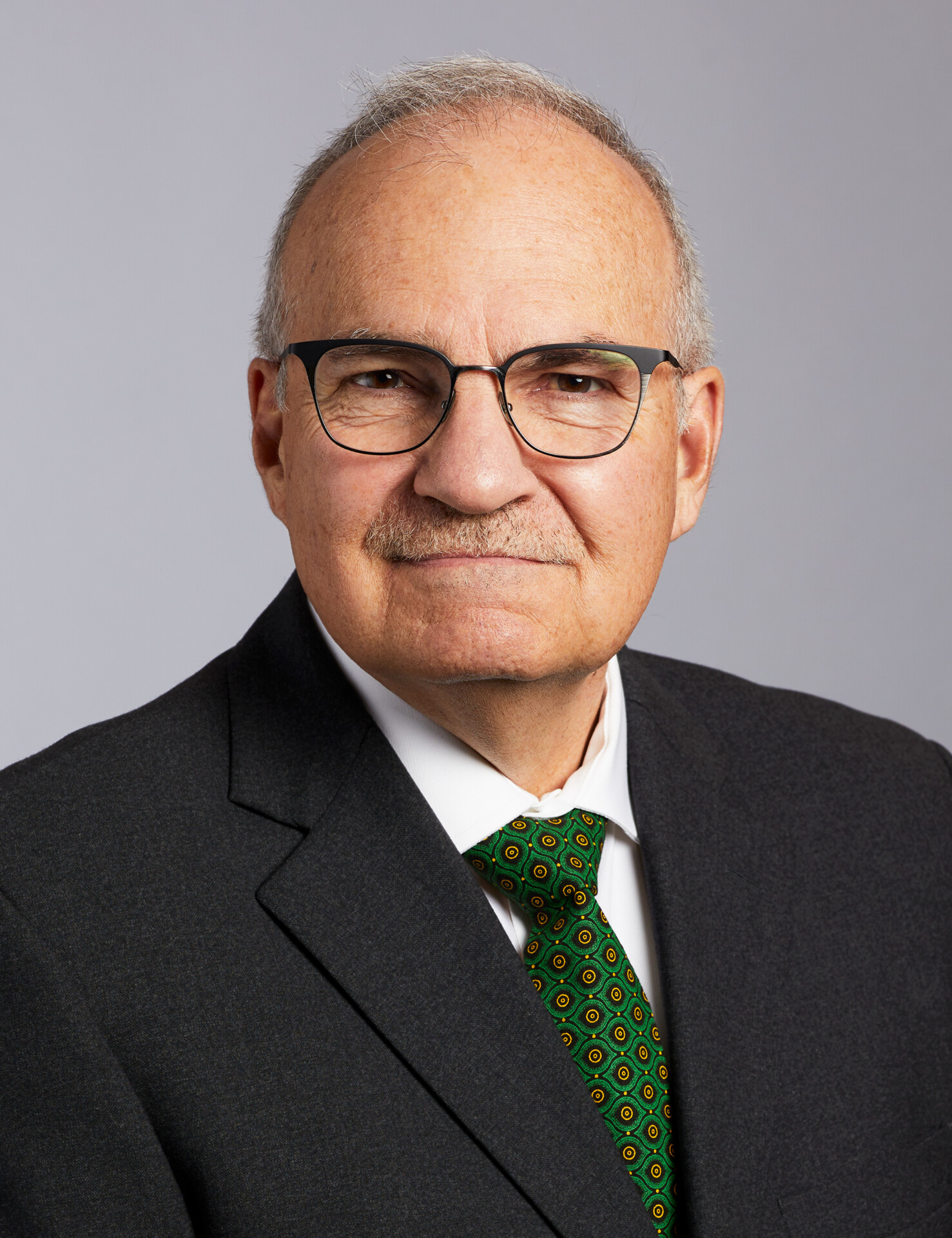 Gary Wolter, wearing glasses and a suit with green tie