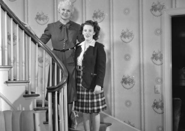Mary and Carol Ann Rennebohm standing on staircase in their home, 1947